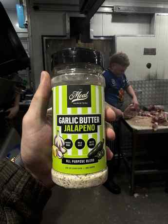 Garlic Butter Jalapeño rub held up in a real butcher shop